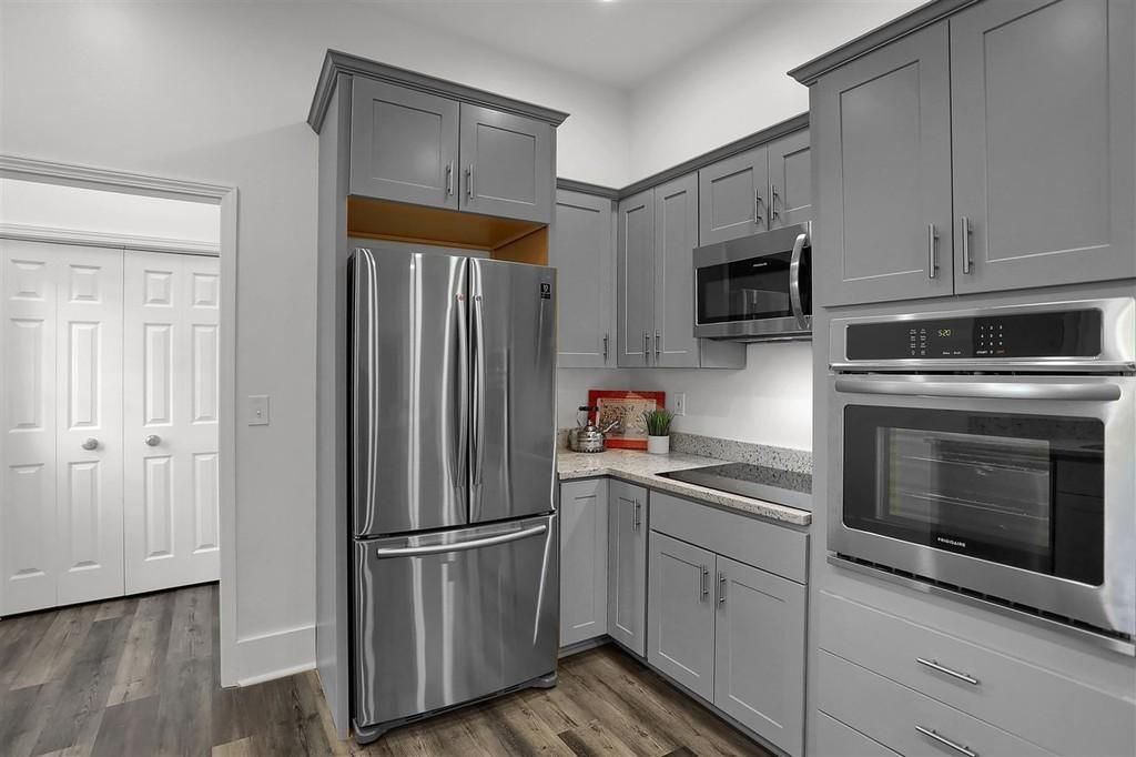 Gray kitchen cabinets and stainless steel appliances in a modern kitchen.