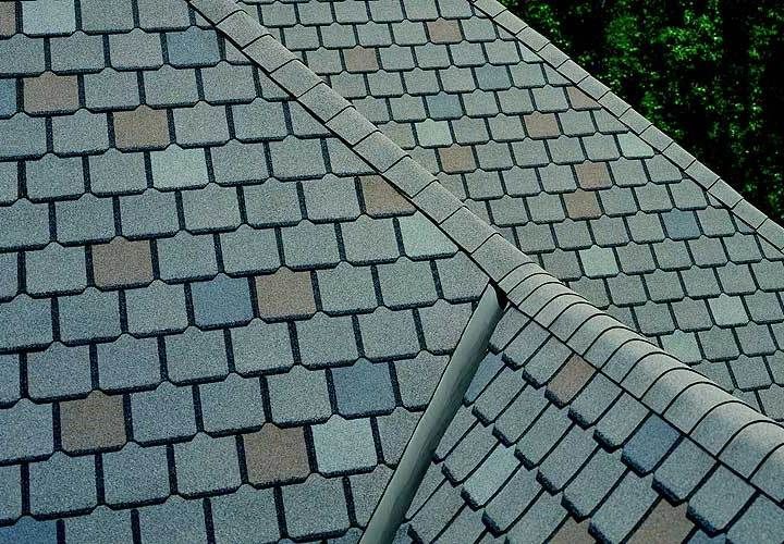 Gray and blue asphalt roof shingles with a ridge and gutter.
