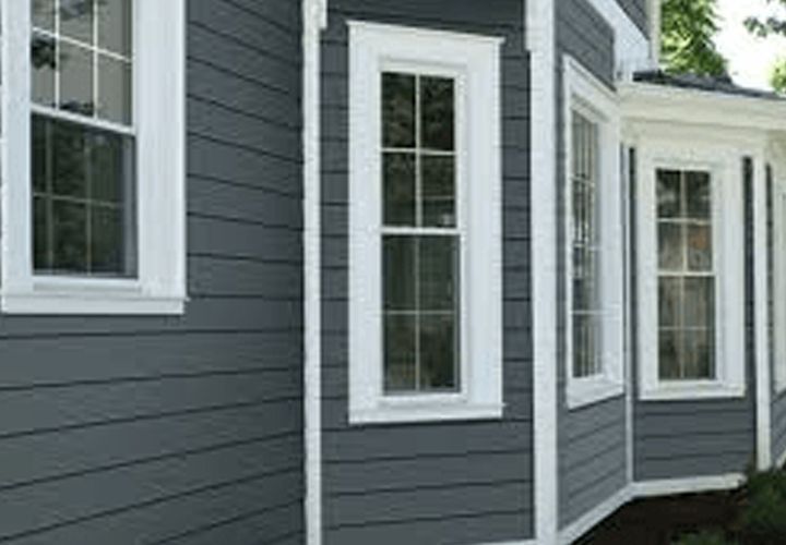 Gray house siding with white window frames.
