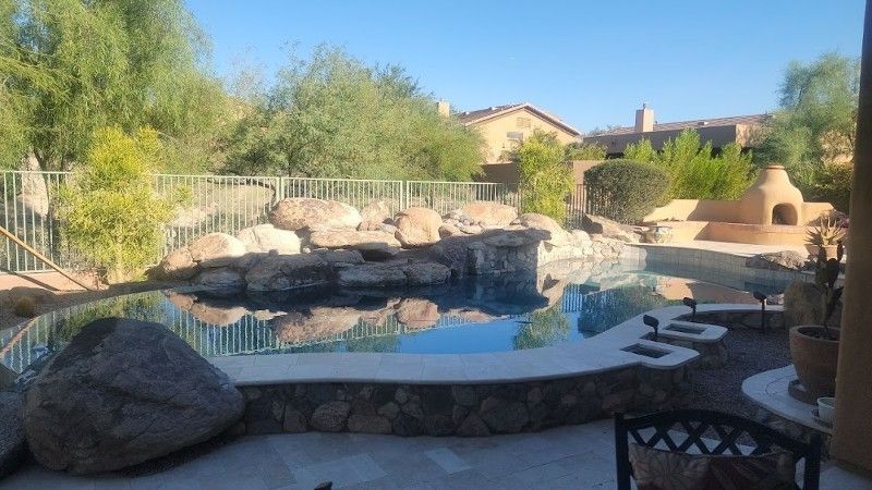 A large swimming pool surrounded by rocks and trees