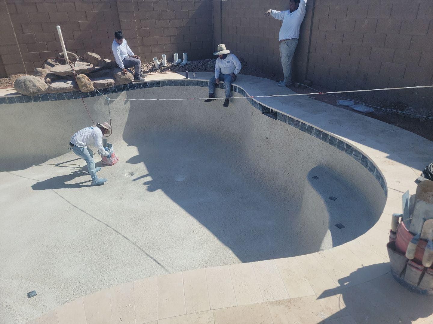 A group of men are working on a swimming pool.