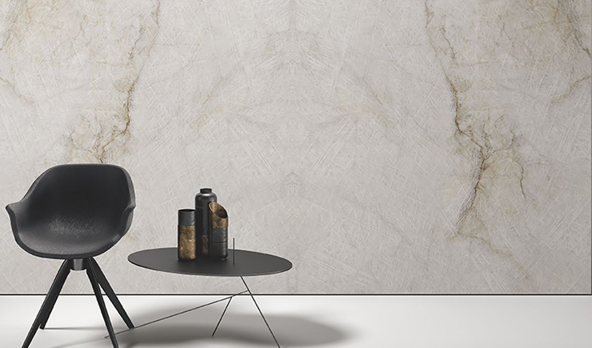 Black chair and round table with bottles against a textured wall in a minimalist room