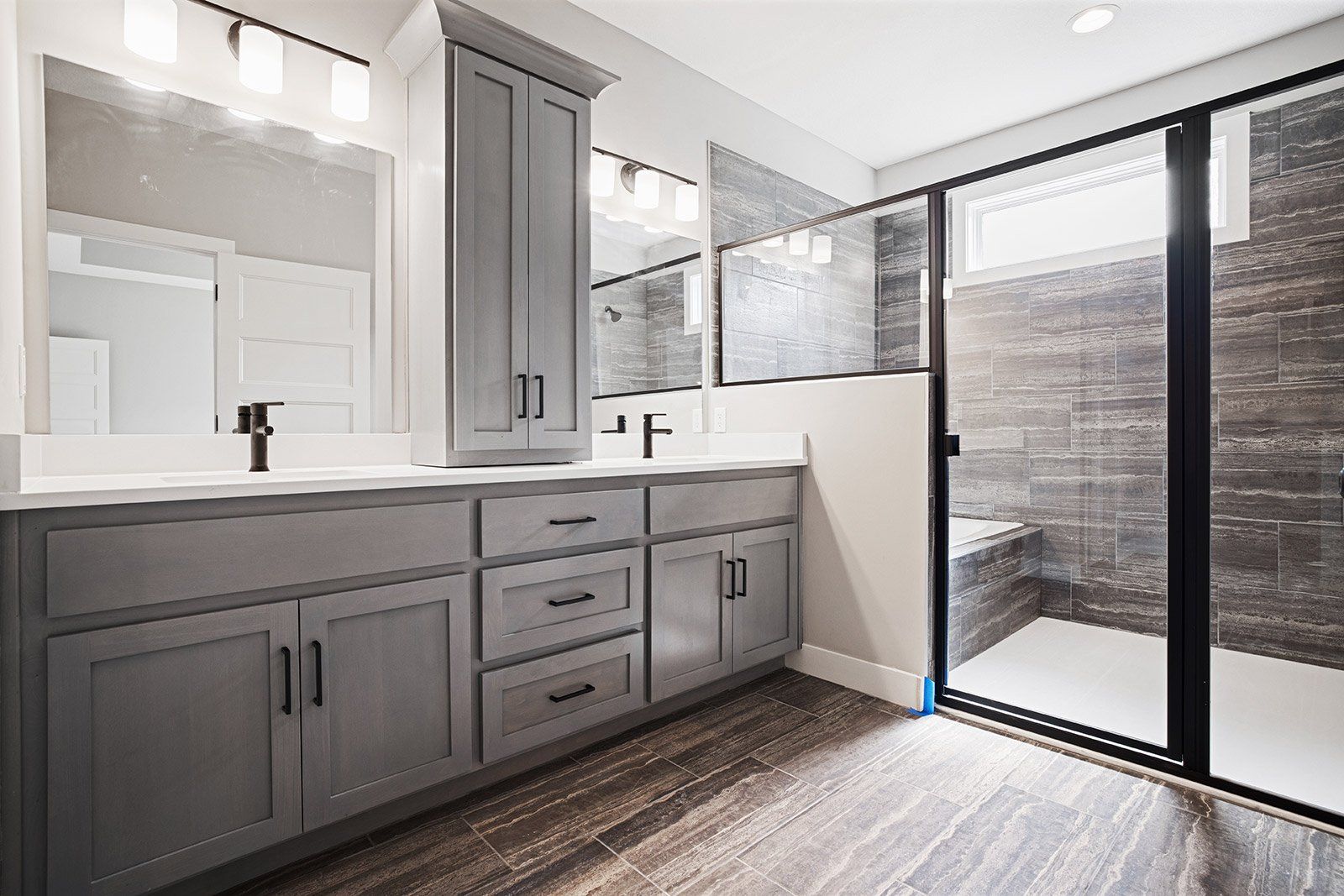A bathroom with two sinks and a walk in shower.