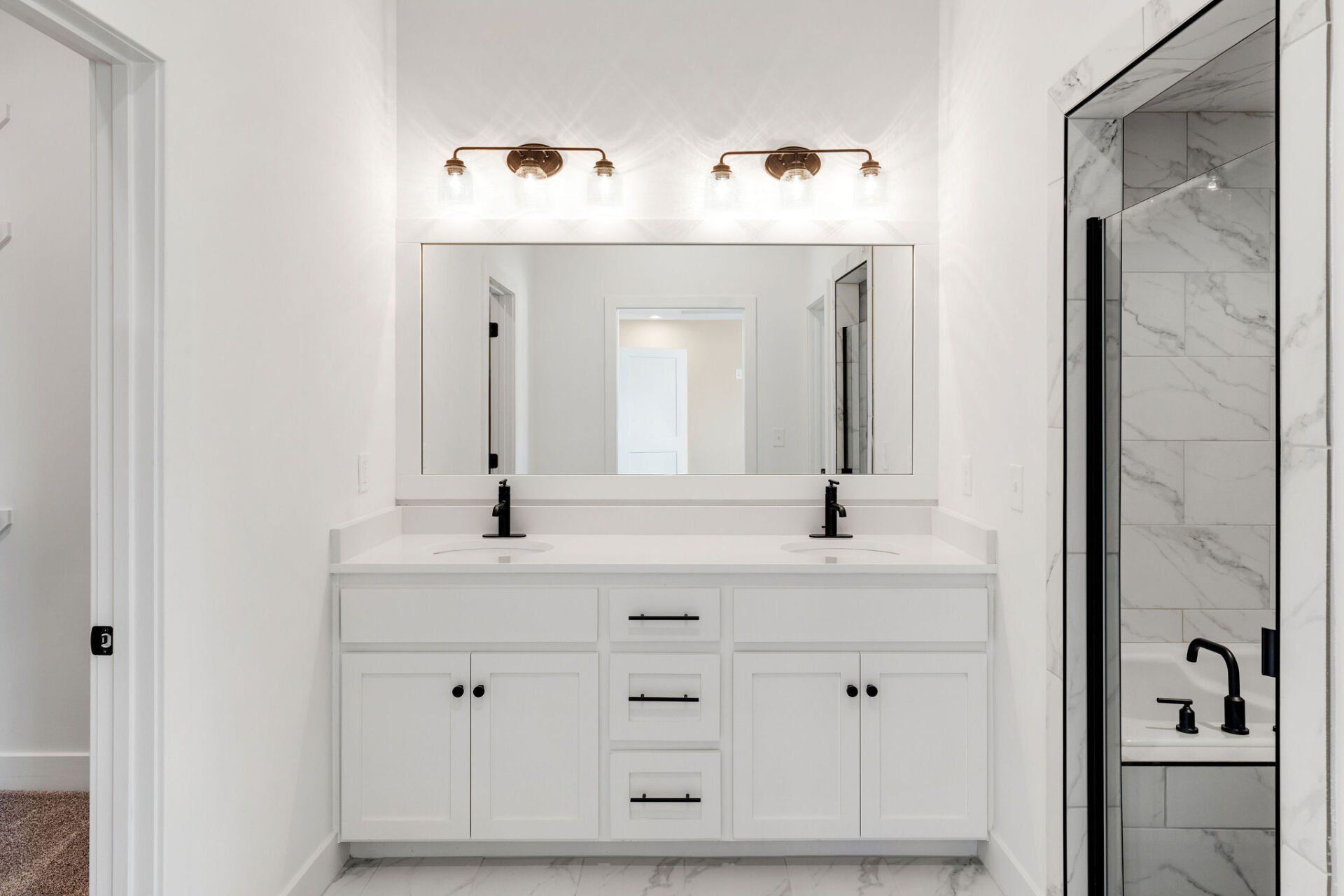 A bathroom with two sinks , a mirror , and a walk in shower.