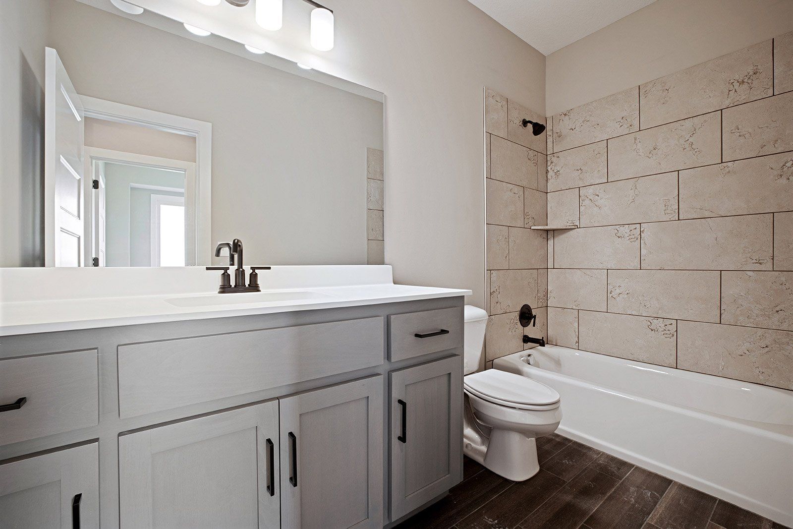 A bathroom with a sink , toilet , tub and mirror.