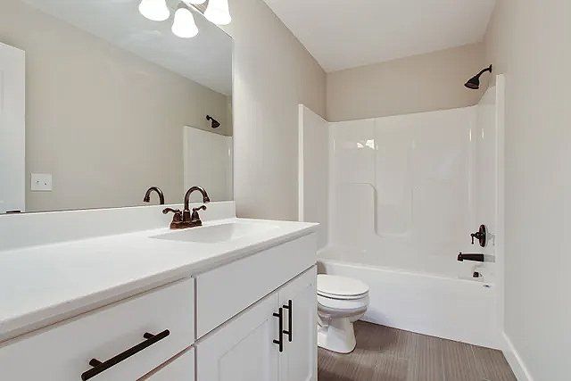 A bathroom with a sink , toilet , bathtub and mirror.