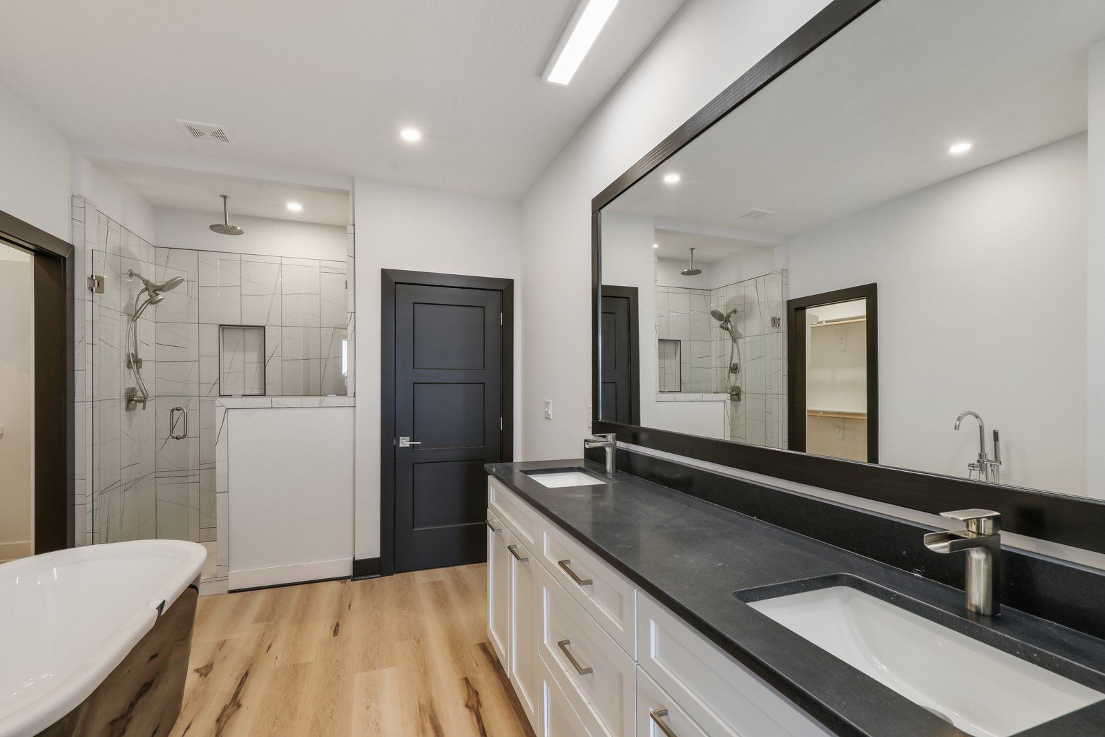 A bathroom with two sinks and a large mirror.