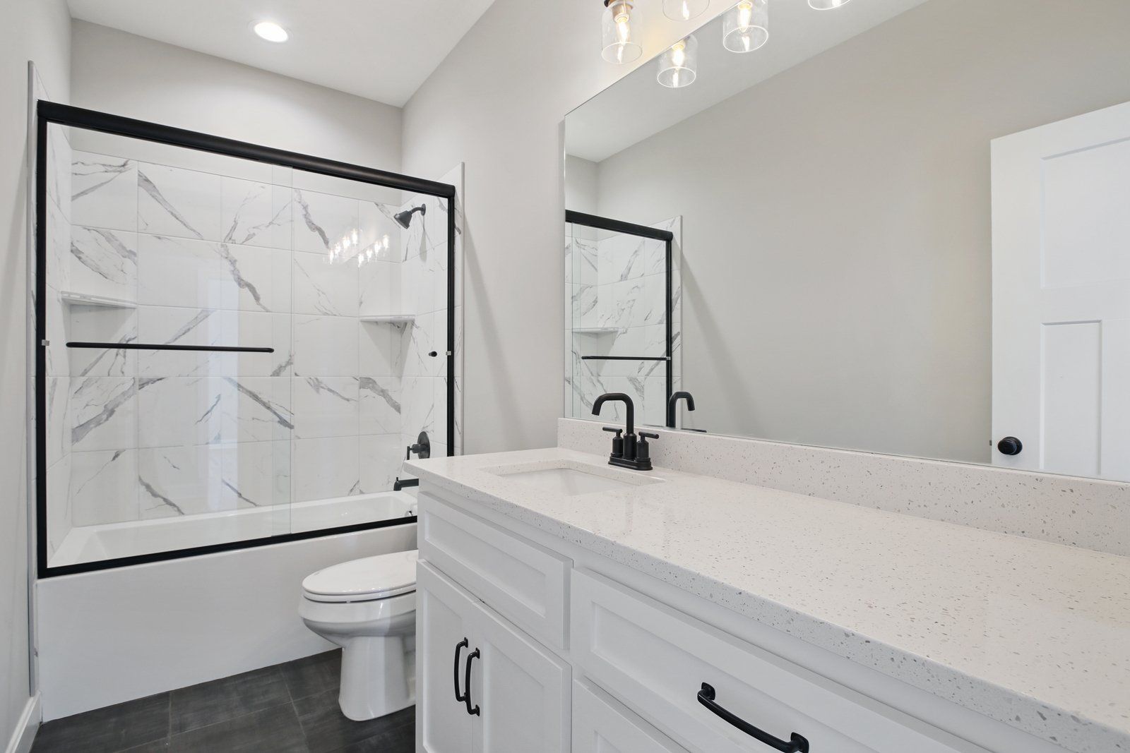 A bathroom with a sink , toilet , bathtub and mirror.
