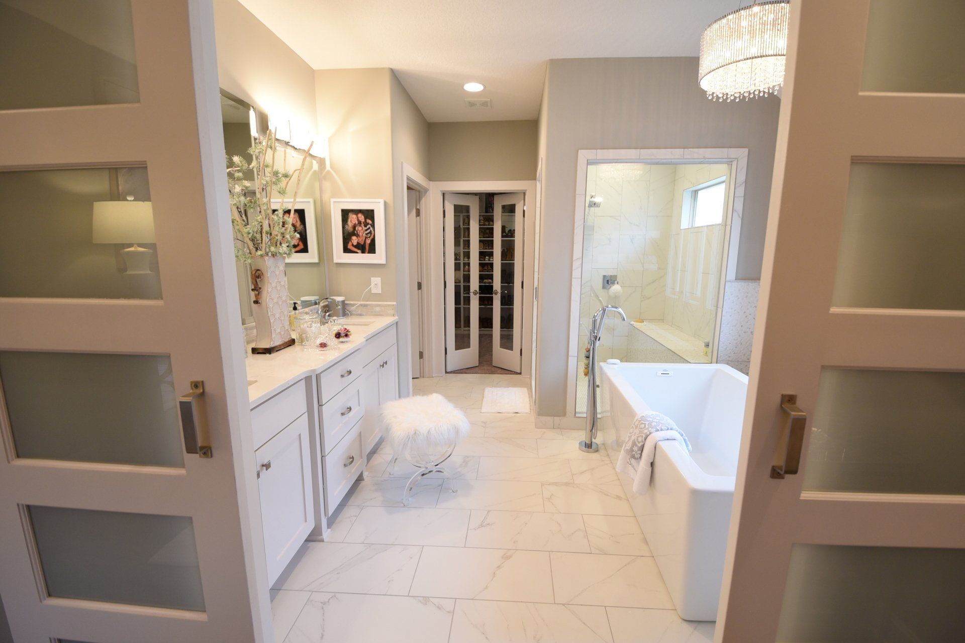 A bathroom with a tub , sinks , mirrors and sliding glass doors