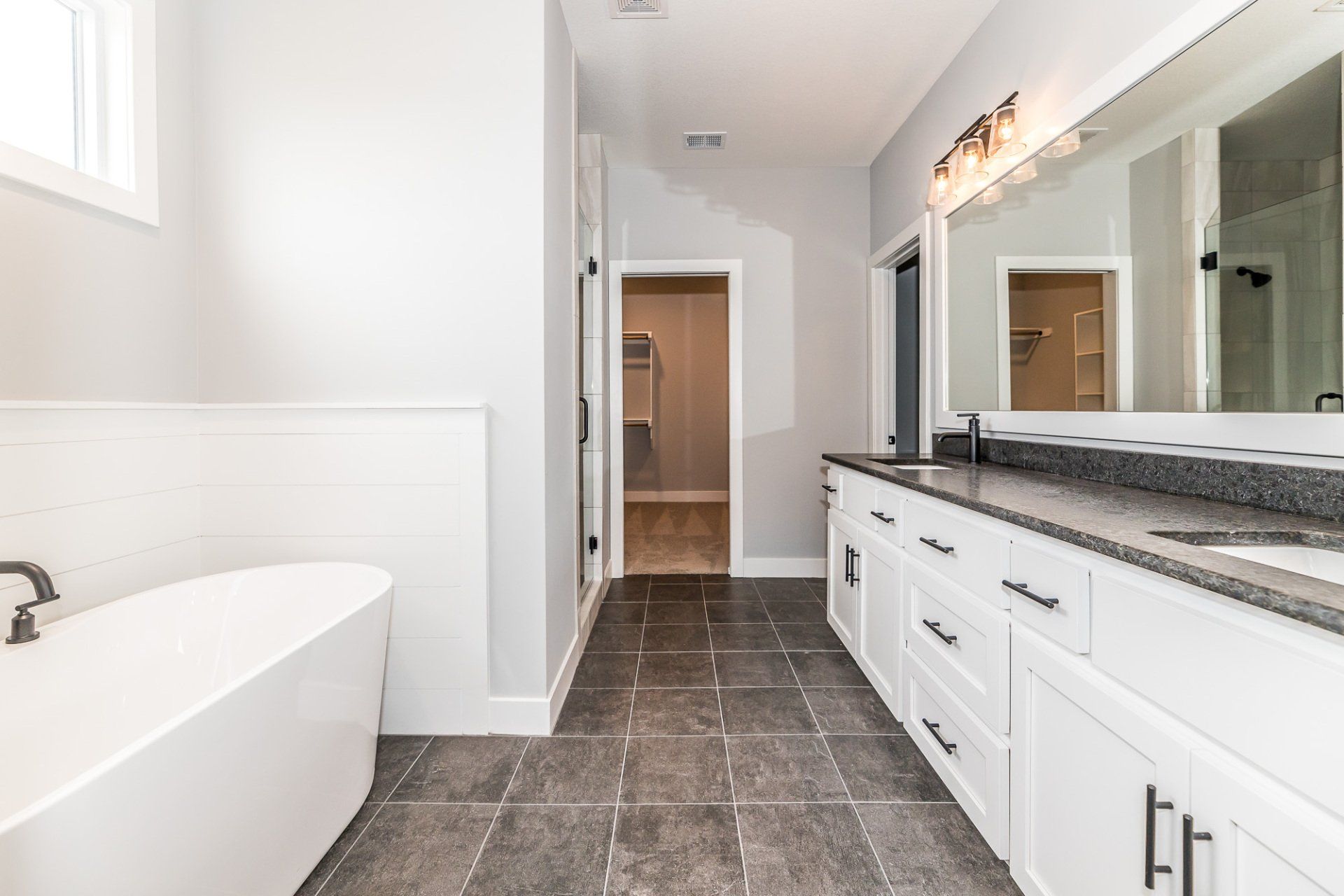 A bathroom with a bathtub , sink , and mirror.