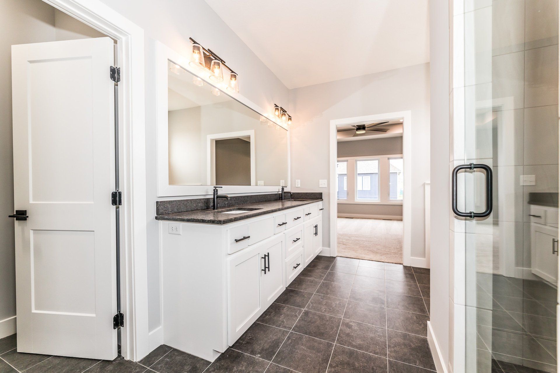 A bathroom with two sinks and two mirrors in a house.