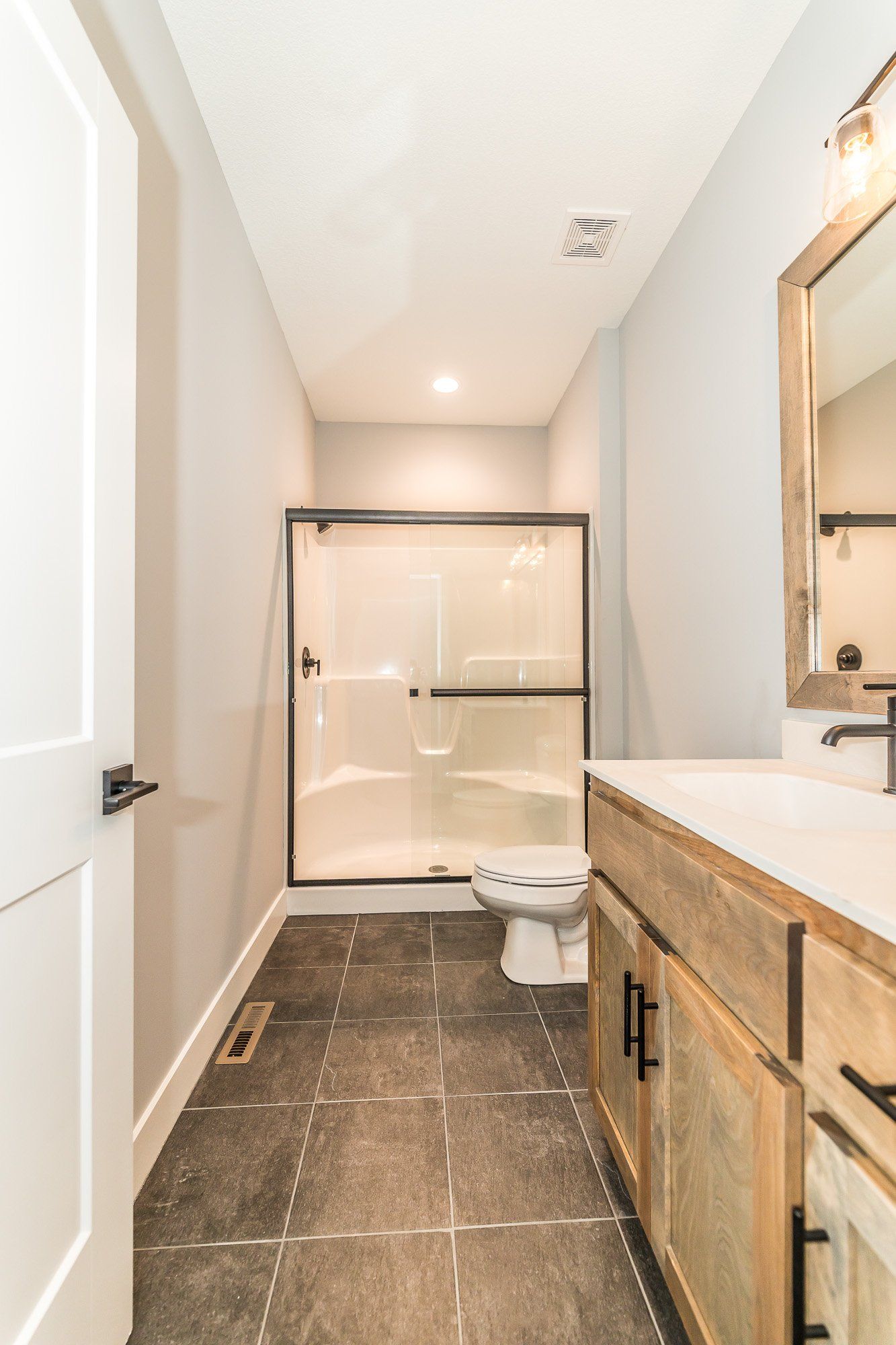 A bathroom with a toilet , sink and shower.