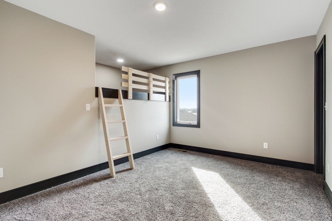 An empty bedroom with a bunk bed and a ladder.