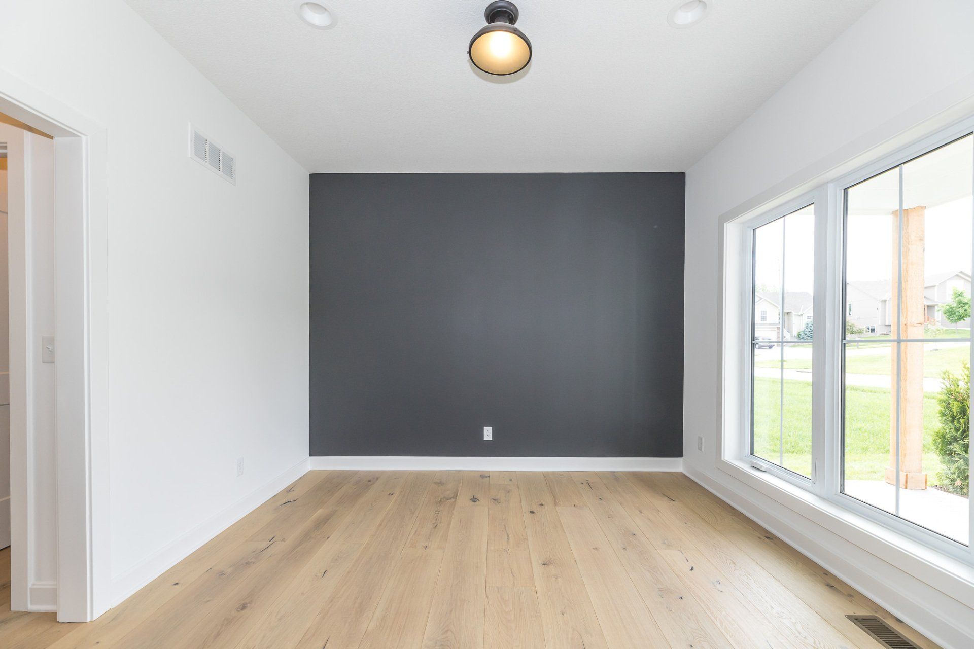 An empty room with hardwood floors and a ceiling fan