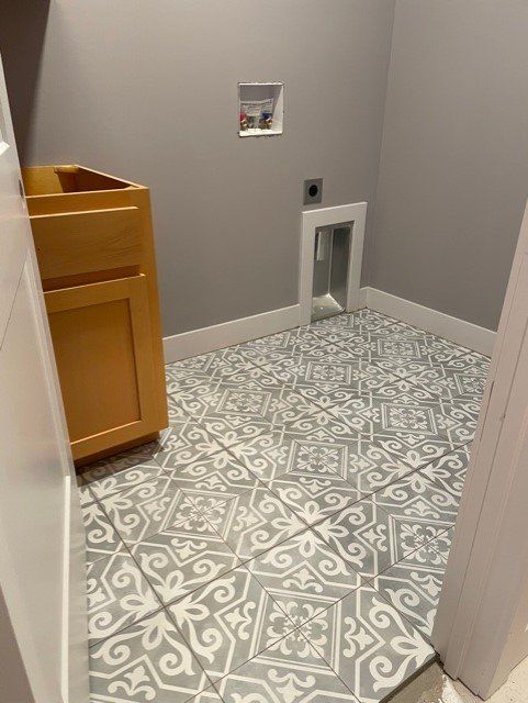 A bathroom with a tiled floor and a sink.