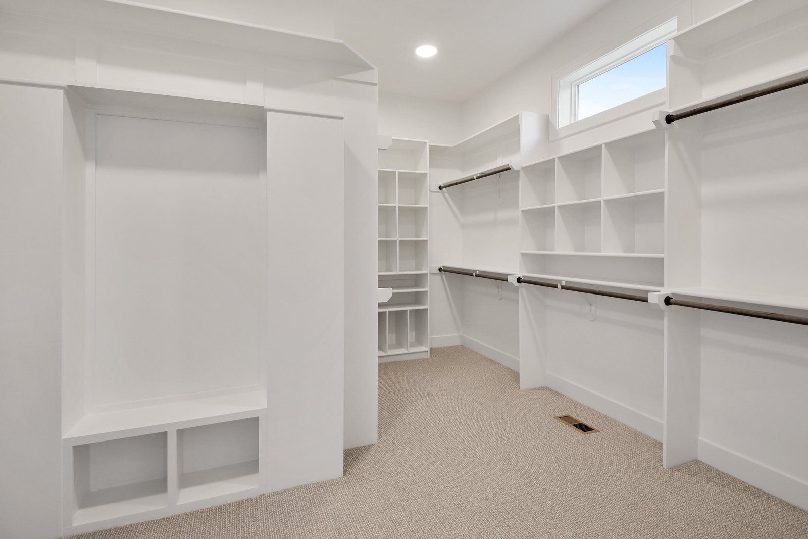A walk in closet with lots of shelves and hanging clothes.