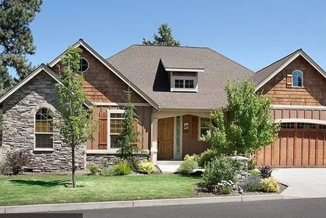 A large house with a garage and a stone facade