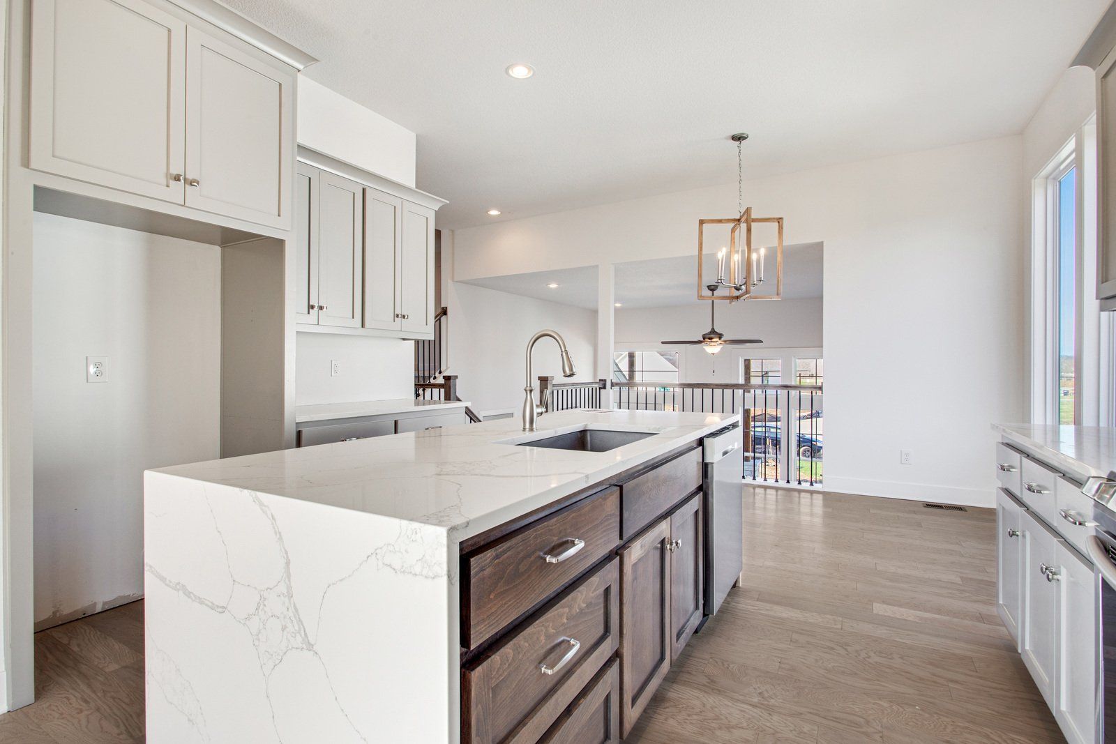 A kitchen with white cabinets and a large island in the middle.