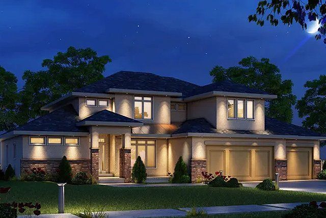 A large house with a blue roof is lit up at night.