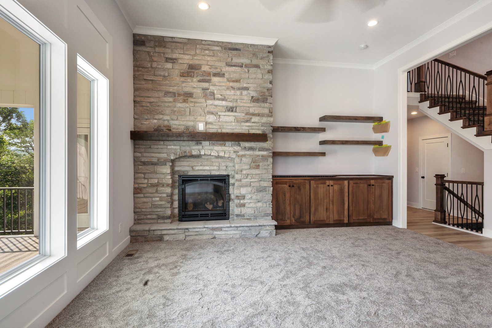 An empty living room with a fireplace and stairs.