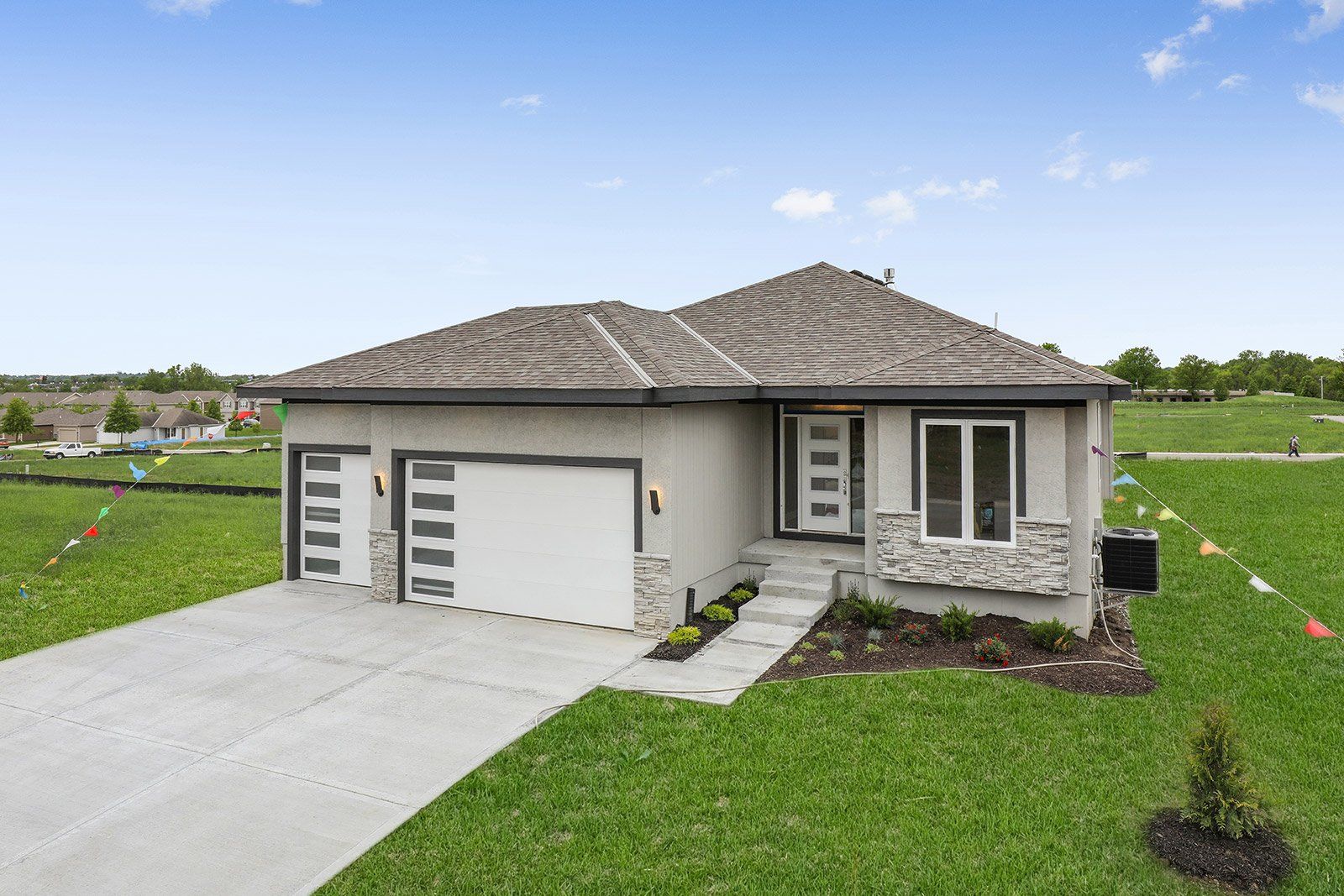 An aerial view of a house with two garages and a driveway.