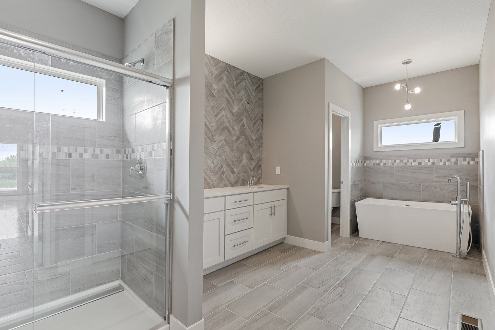 A bathroom with a tub , sink , shower and window.