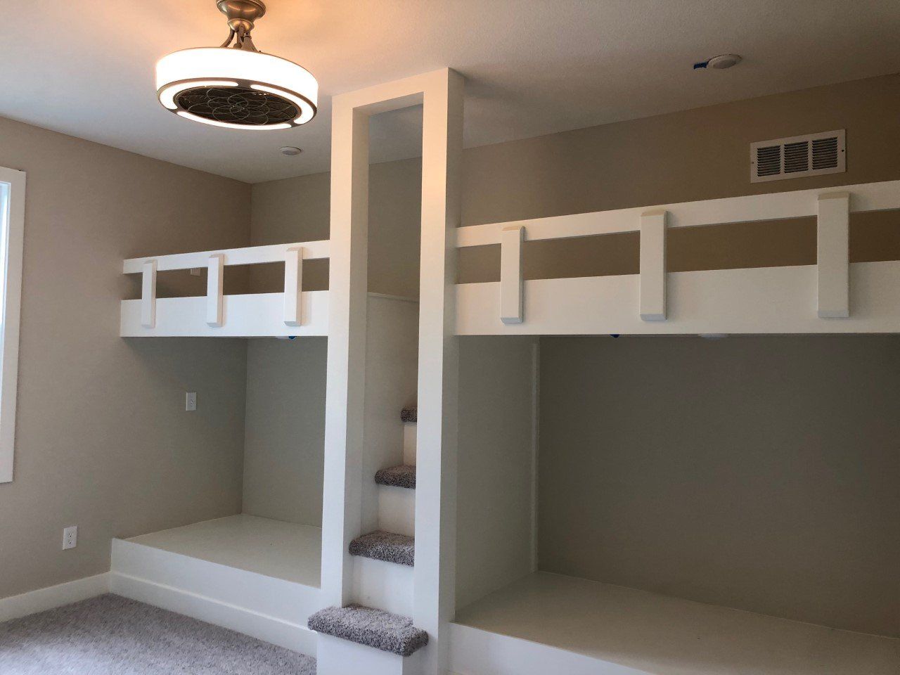 A bedroom with bunk beds and a ceiling fan