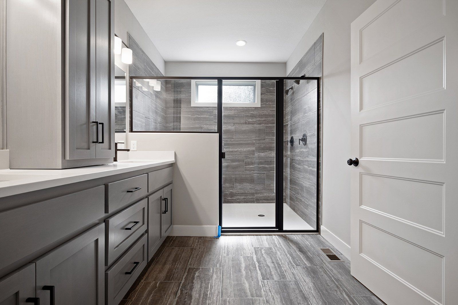 A bathroom with a walk in shower and a sink.