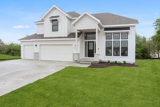 A large white house with a large lawn in front of it.