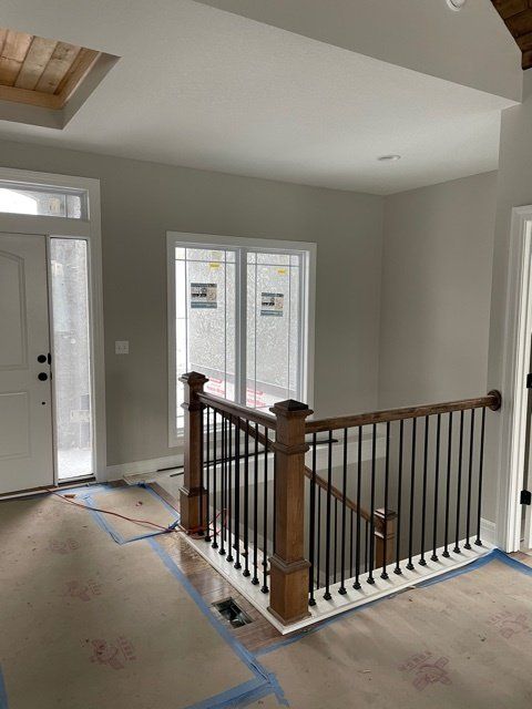 An empty room with a staircase and a door.