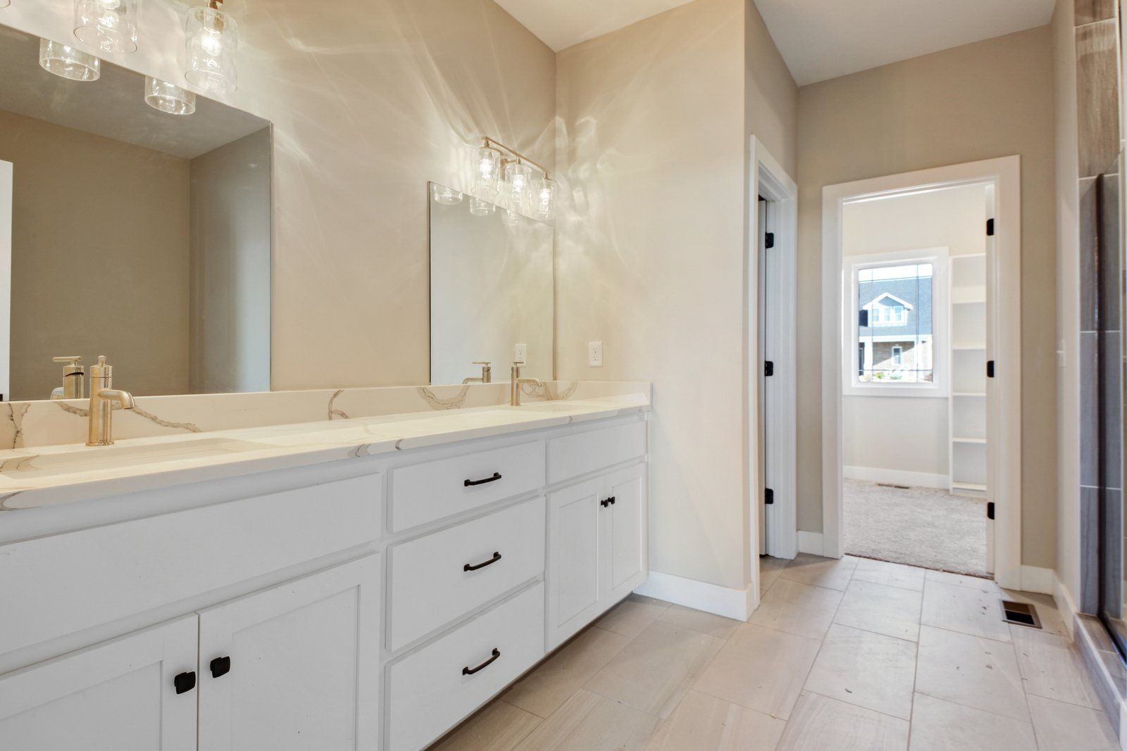 A bathroom with two sinks , a mirror and a walk in shower.