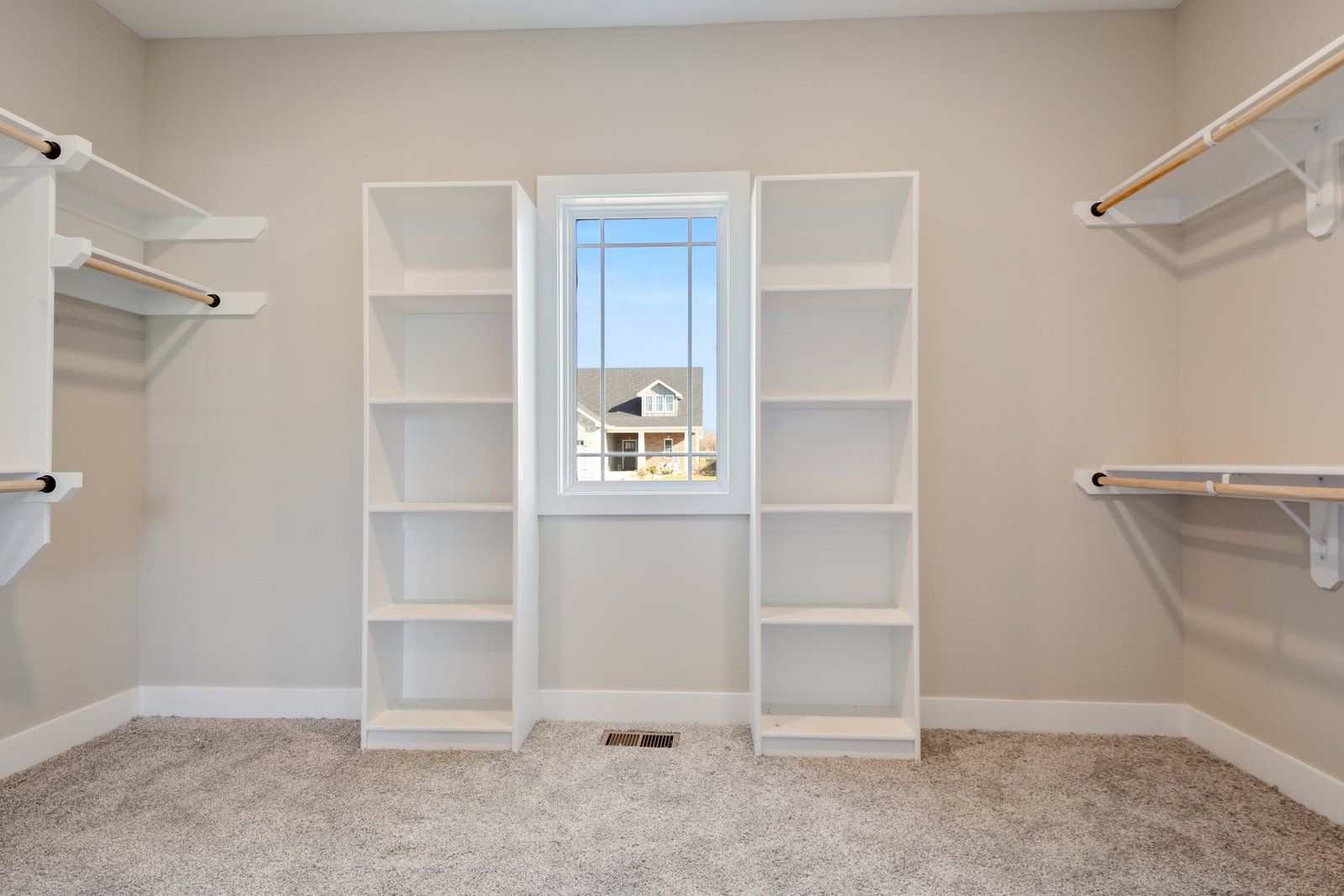 An empty walk in closet with shelves and a window.