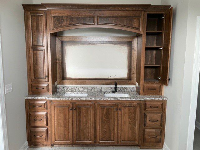 A bathroom with wooden cabinets and a sink.