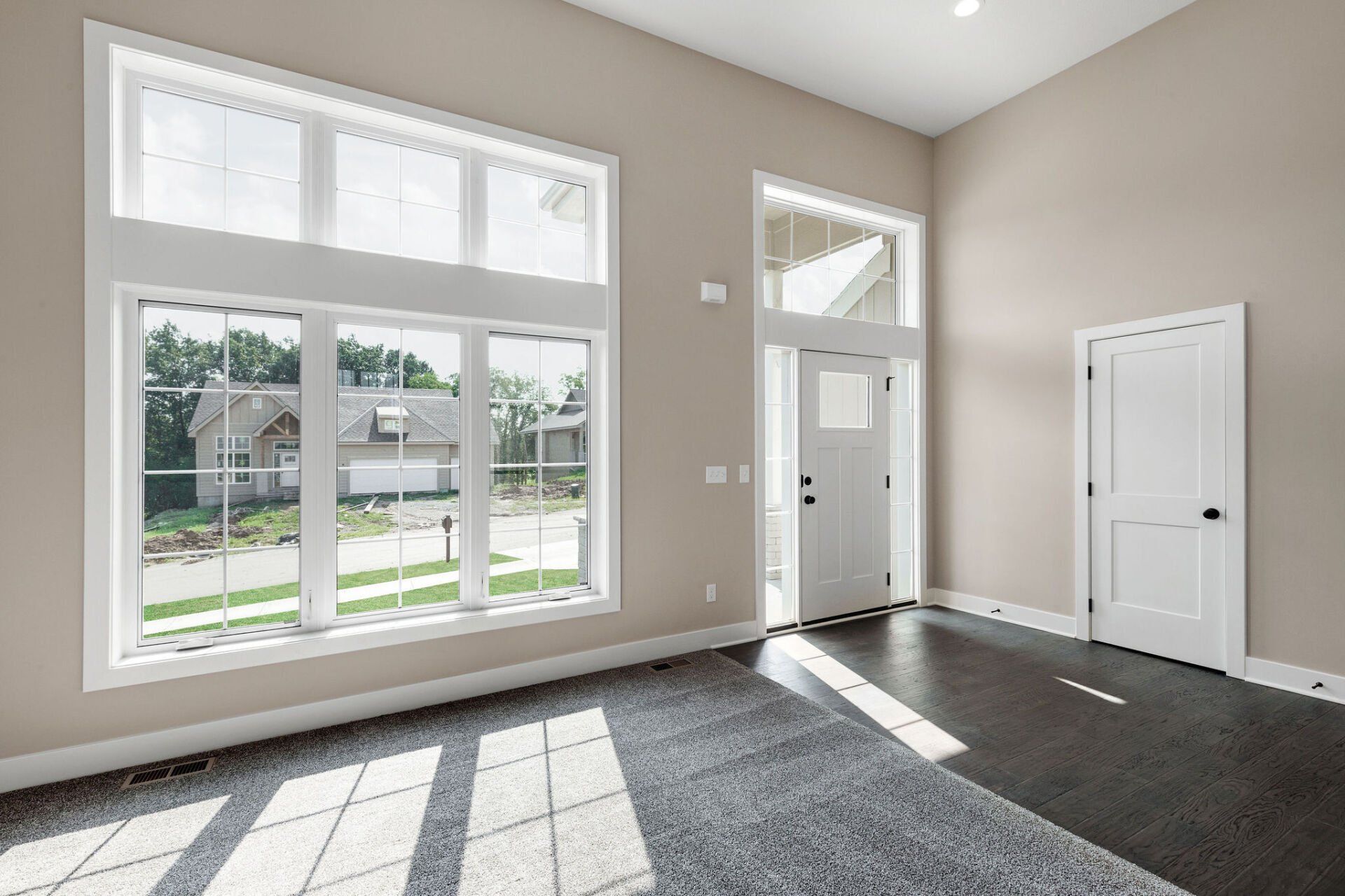 An empty room with a lot of windows and a door.