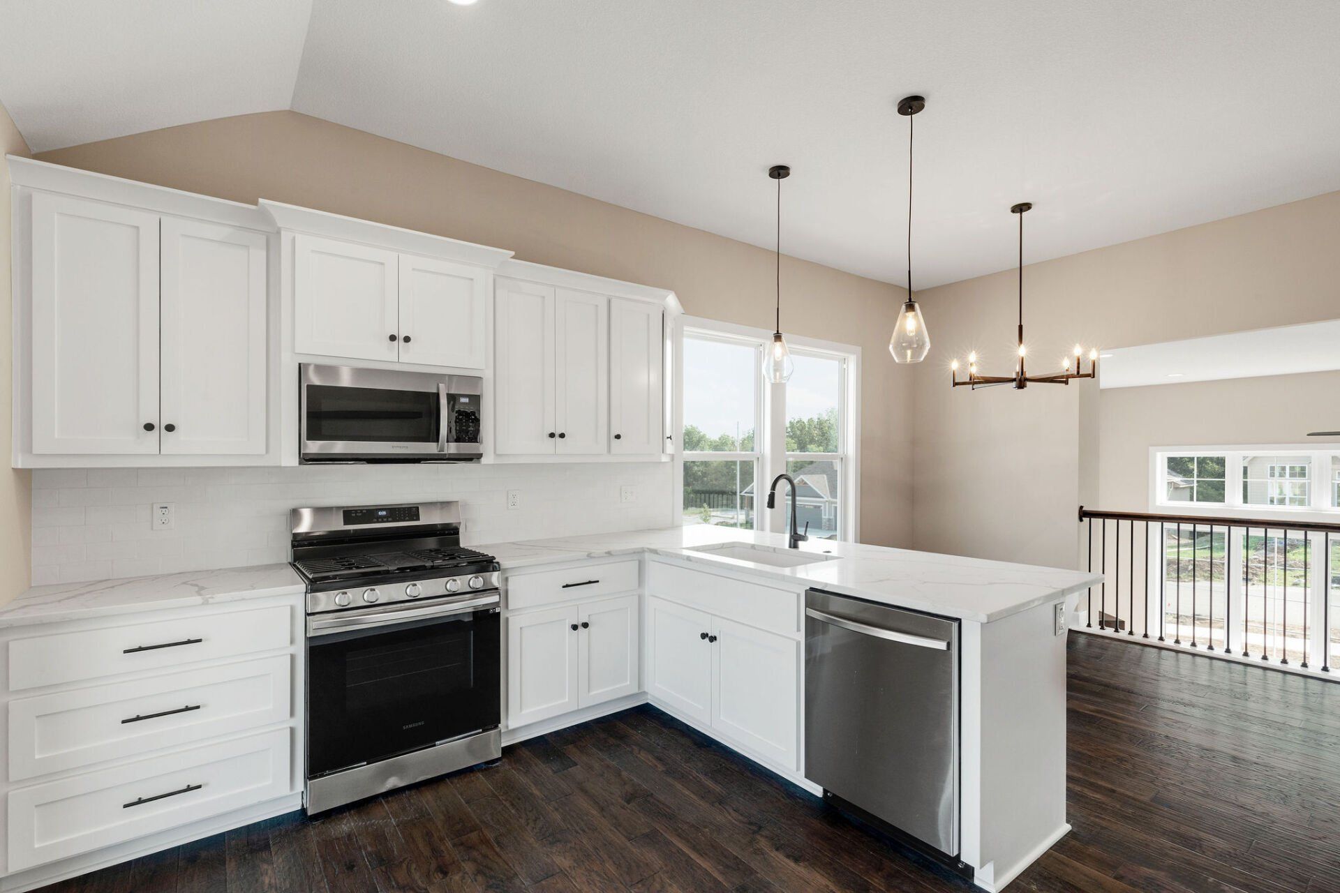 A kitchen with white cabinets , stainless steel appliances , and a large island.