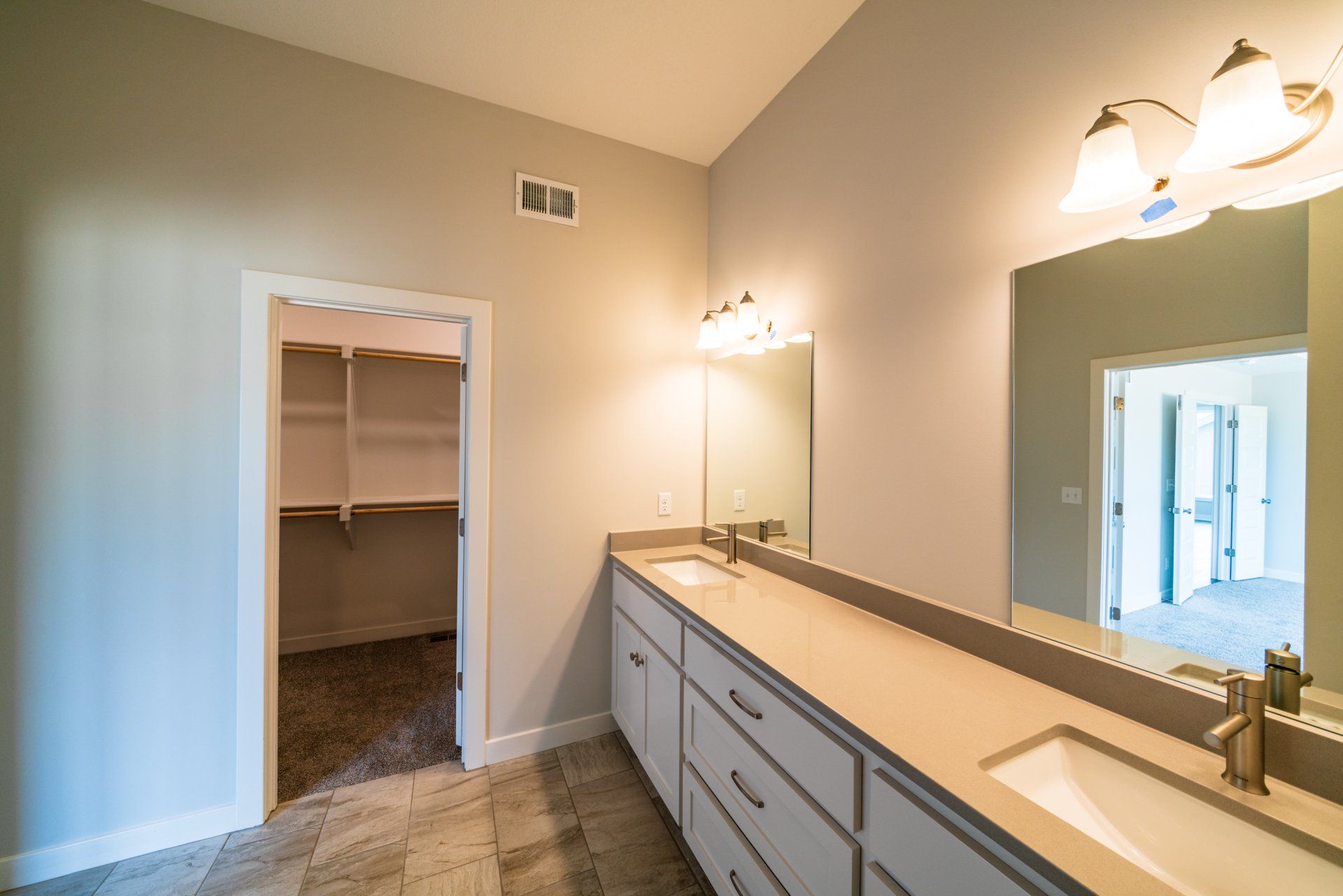 A bathroom with two sinks and a large mirror.