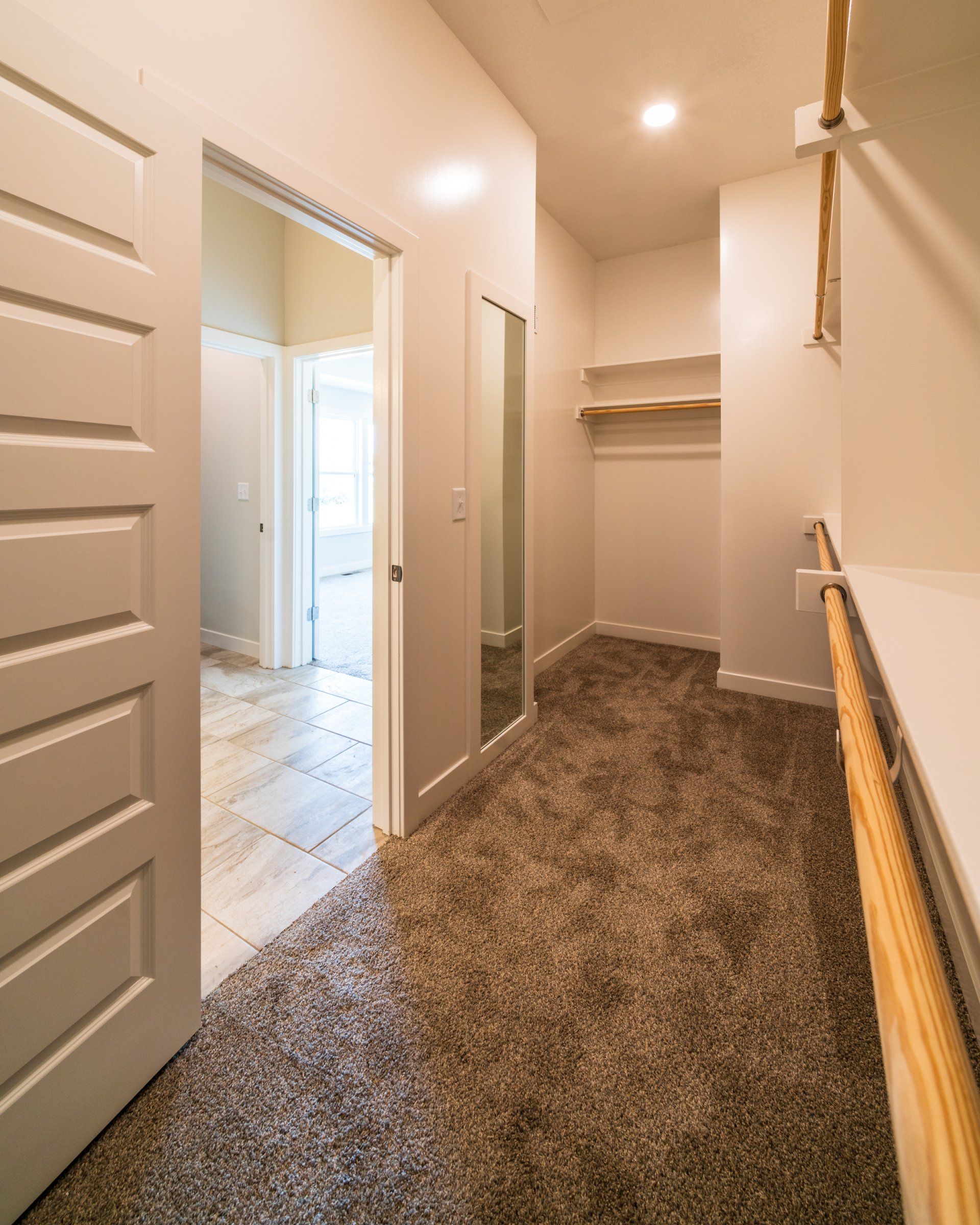 A walk in closet with a rope railing and a mirror.