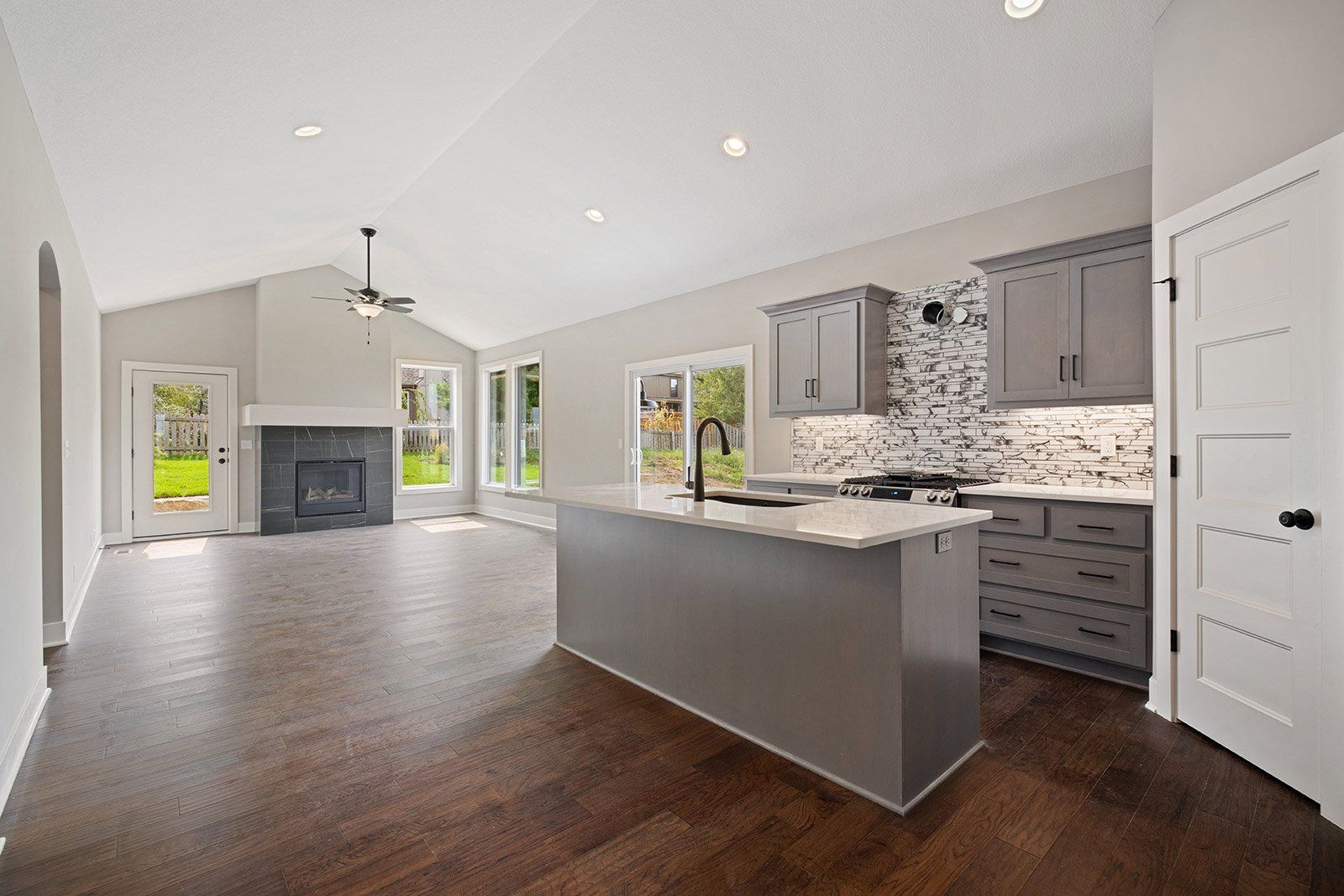 A kitchen with a large island and a fireplace in a house.