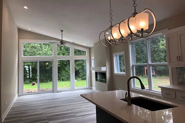 A kitchen with a sink and a chandelier hanging from the ceiling.