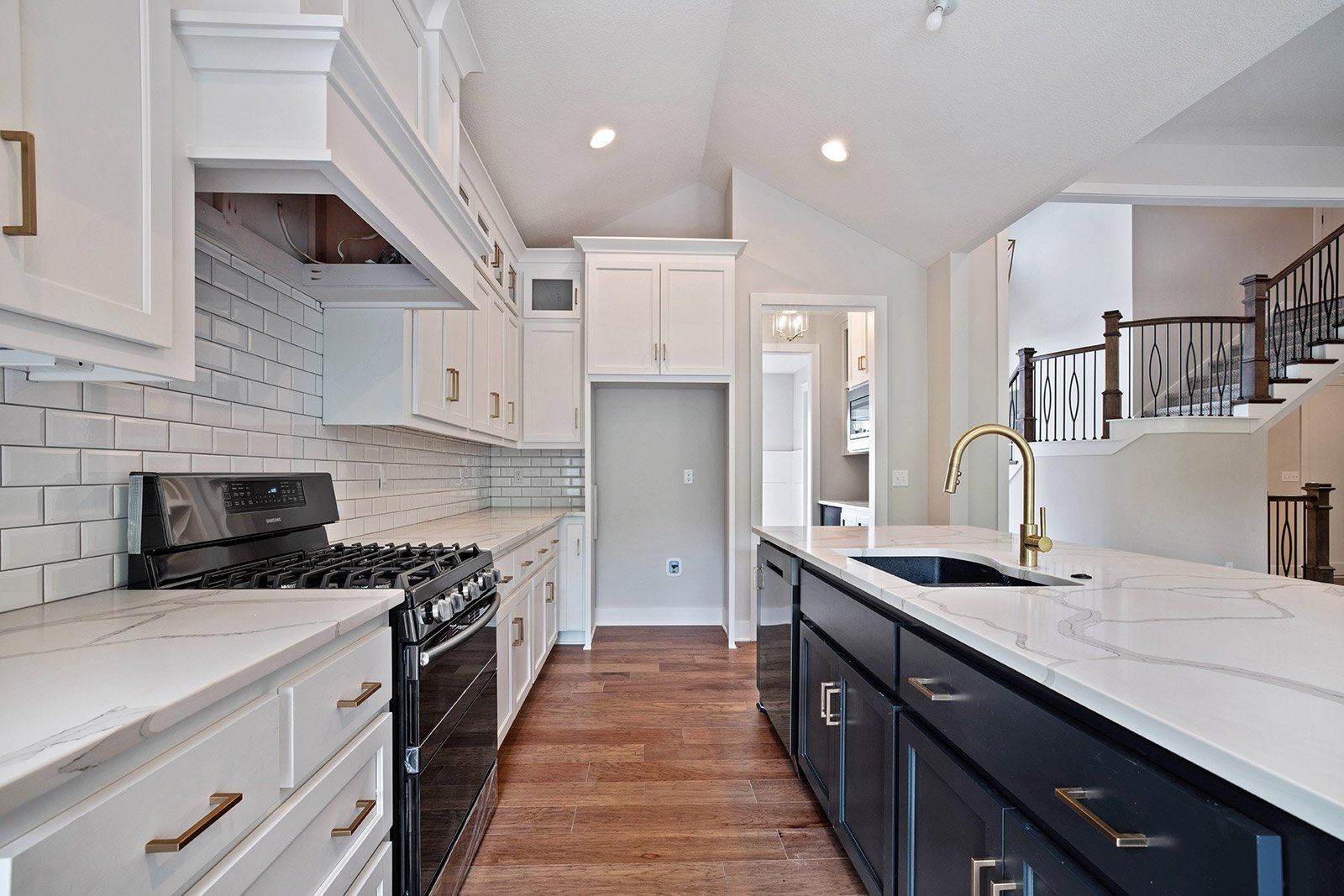 A kitchen with white cabinets and black appliances and a sink