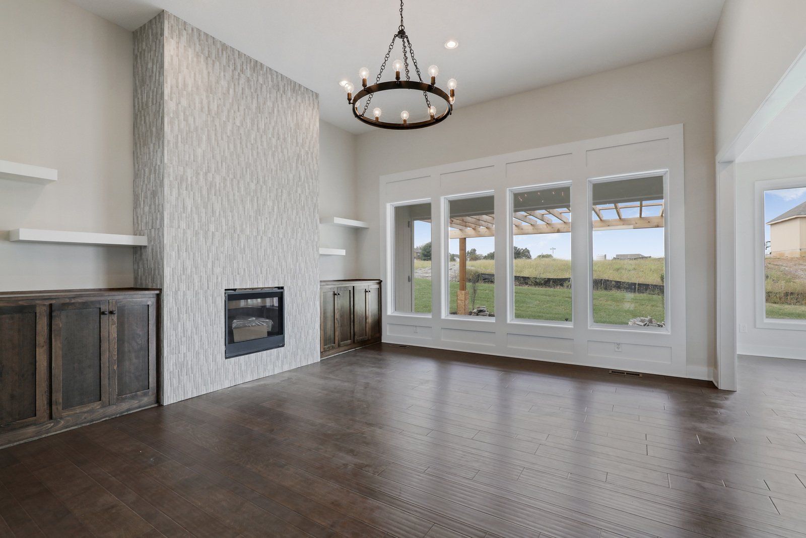 An empty living room with a fireplace and lots of windows.