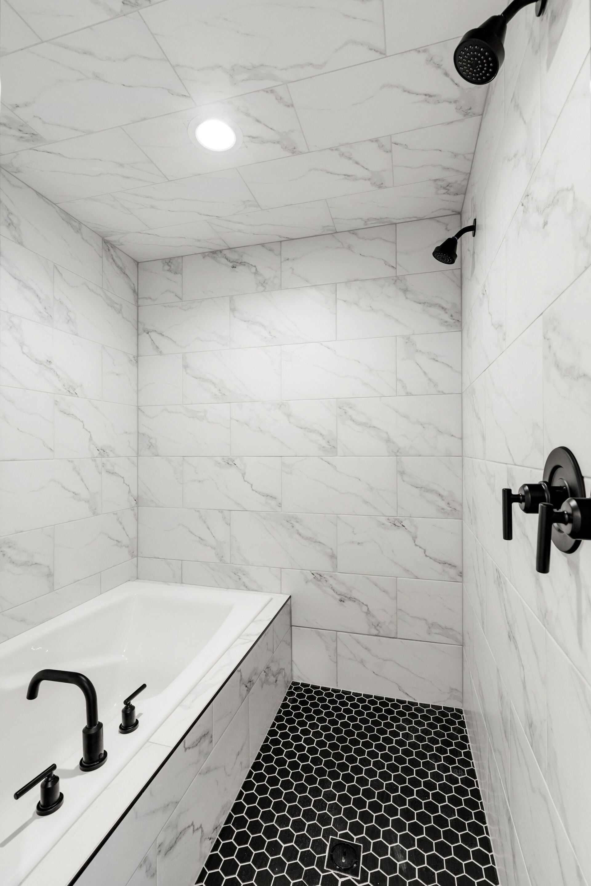 A black and white photo of a bathroom with a bathtub and shower.