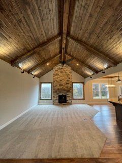 A living room with a vaulted ceiling and a fireplace.