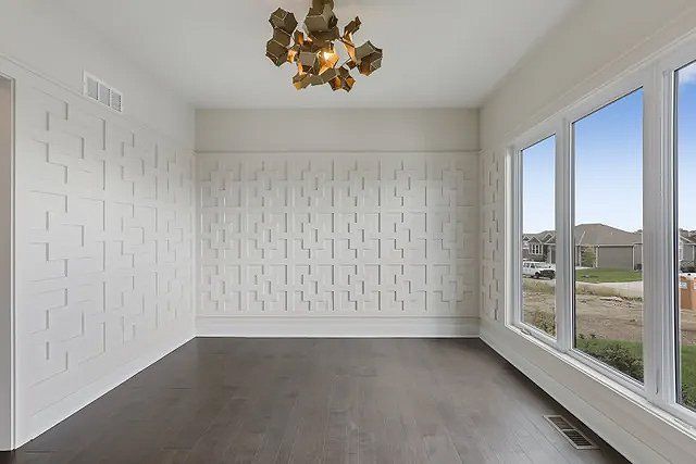 An empty room with a lot of windows and a chandelier.