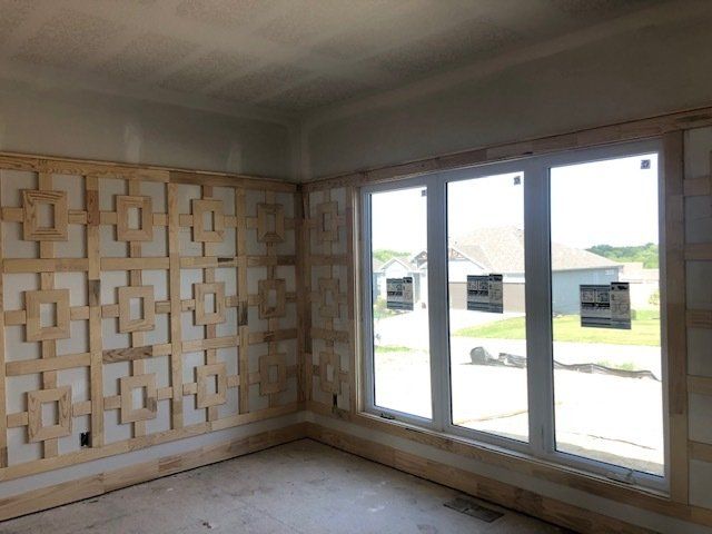 A room with a lot of windows and a wooden wall.