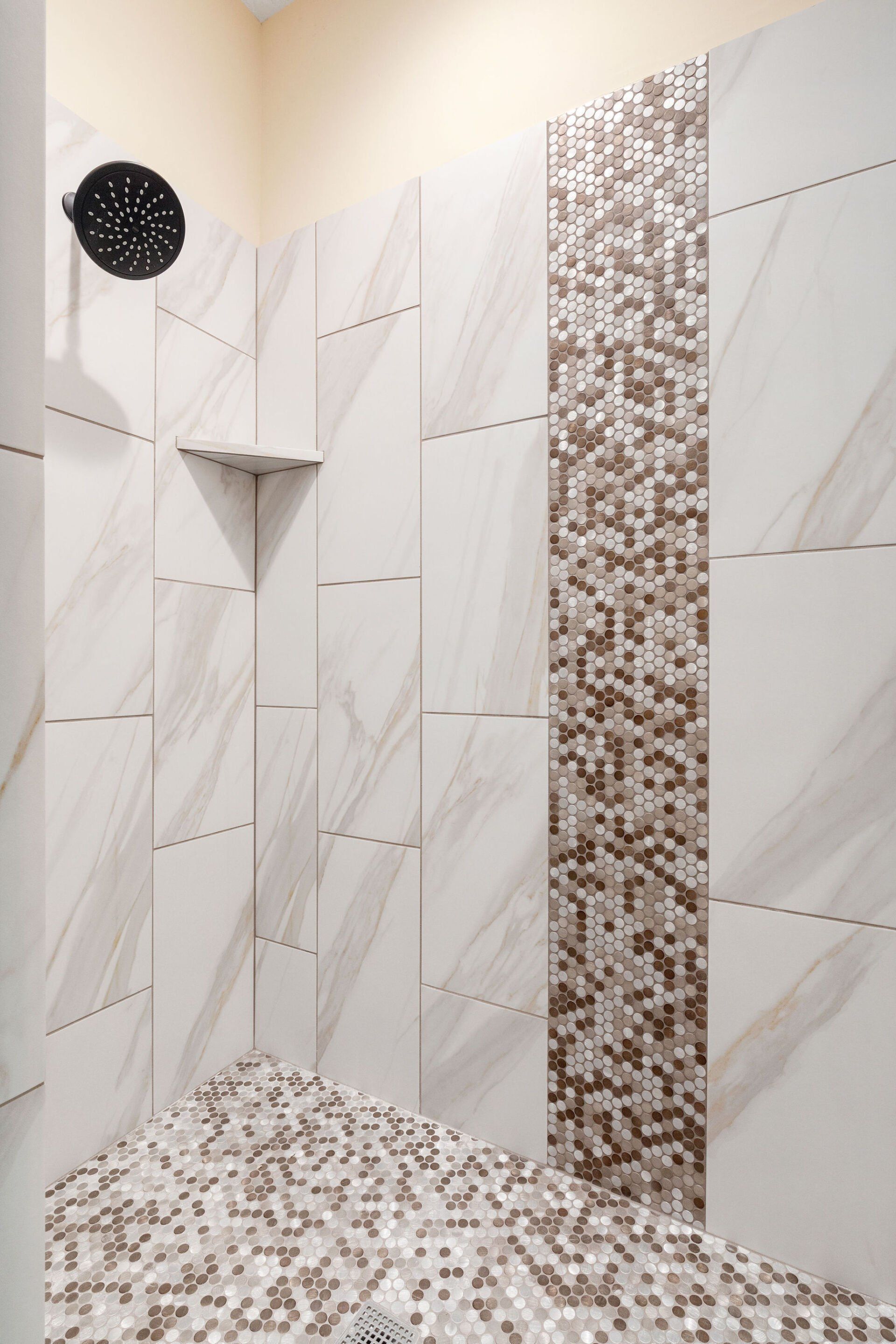 A shower with white tiles and a mosaic wall