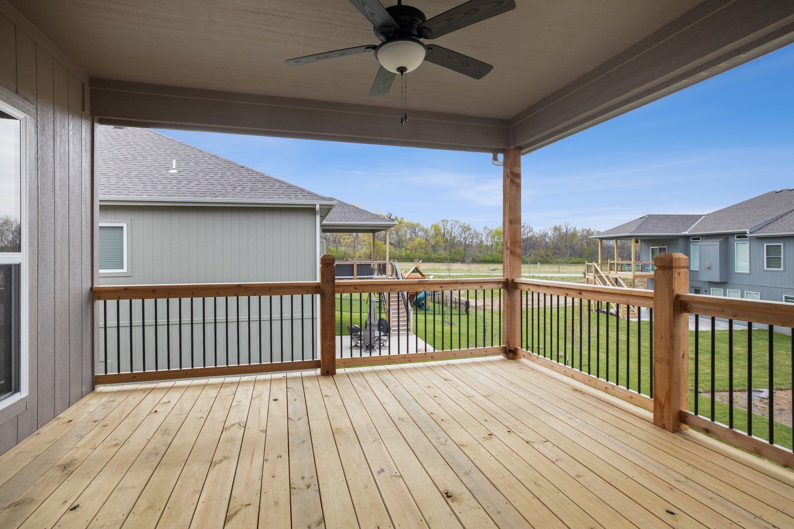 There is a ceiling fan on the deck of a house.