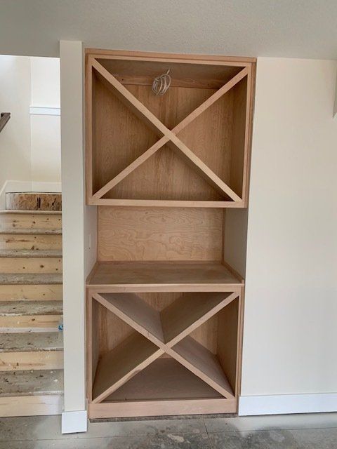 A wooden wine rack in a room with stairs in the background