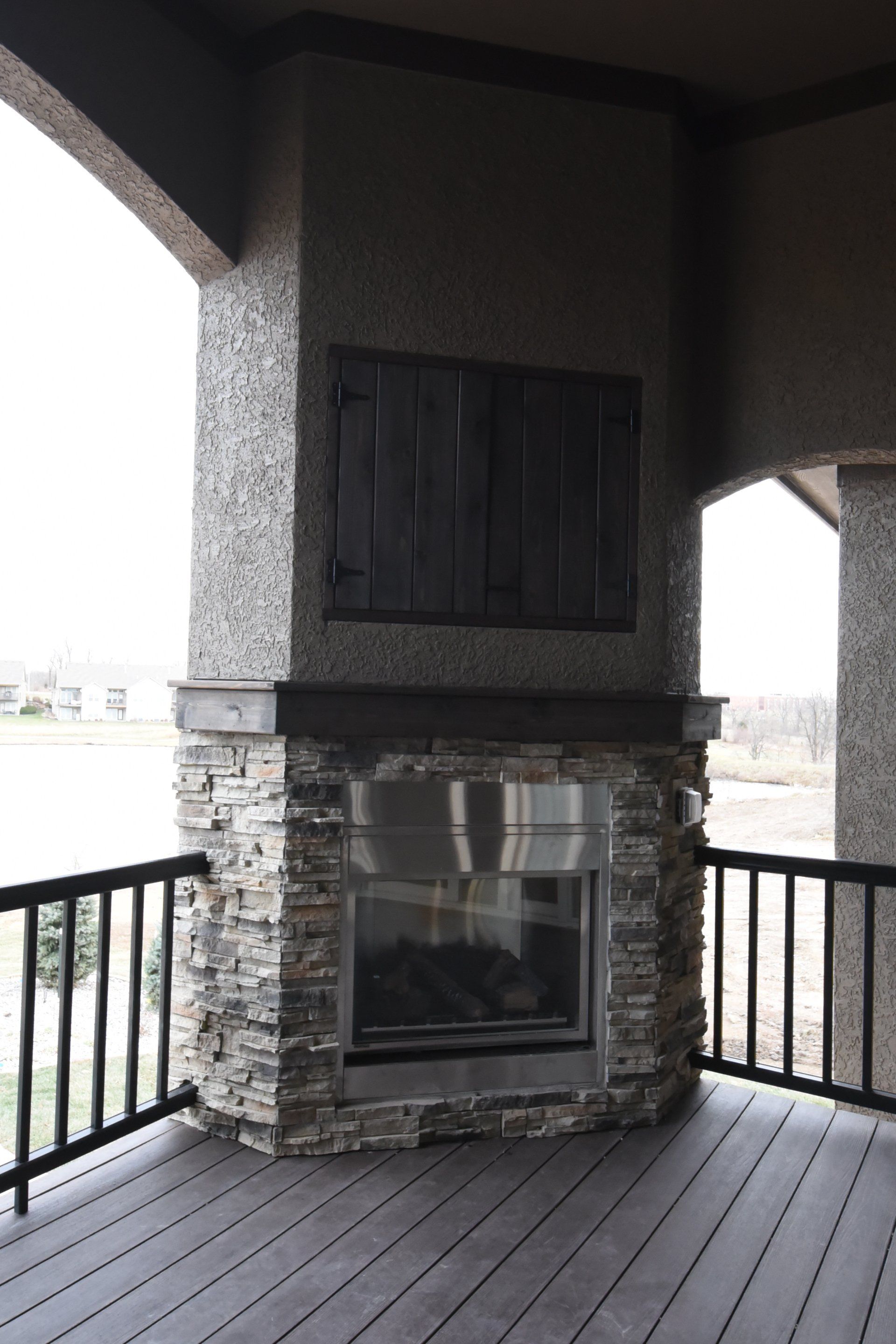 There is a fireplace on the deck of a house.