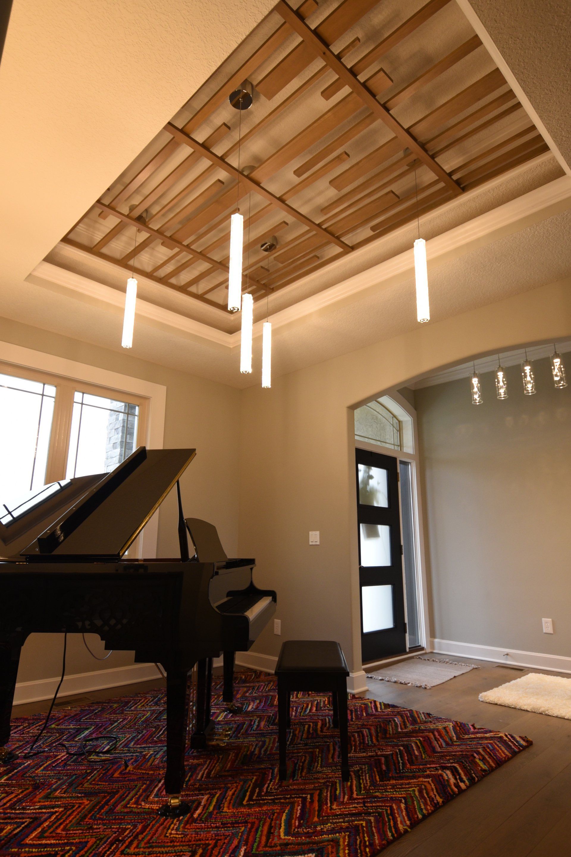 A piano is in a room with a wooden ceiling